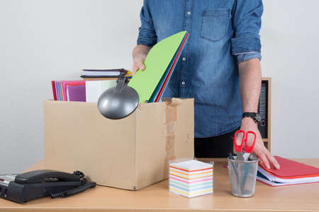 man unrecognizable preparing the box beacause he is fired