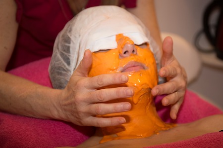 Voman having Fresh carrots facial Mask apply by beauticianの写真素材