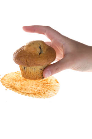 Female hand catch chocolate muffin against white backgroundの写真素材