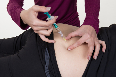 Doctor female gives an injection to a manの写真素材