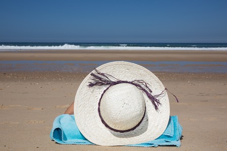 Girl lies on the white sand on the beach symbol of holidaysの写真素材