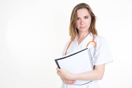 Smiling female doctor with a folder in uniform standing at hospital.の写真素材