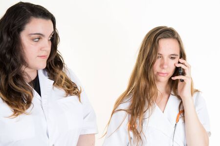 Medical team on a hospital over white background, woman nurse on phoneの写真素材