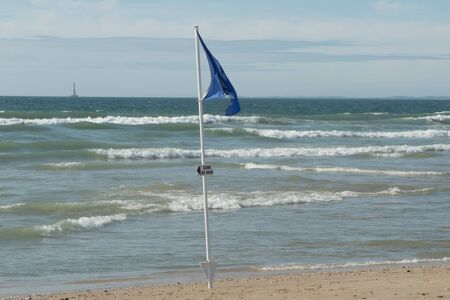 Blue flag on beach, in France at the seasideの写真素材