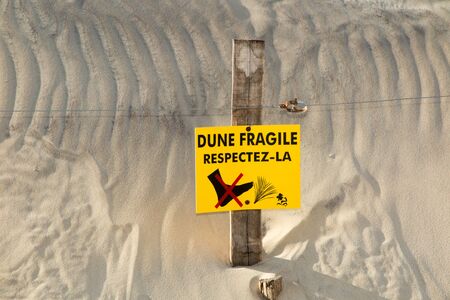 Beach Dunes and wooden picket fence, with sign warning Do Not Walk On Dunesin french