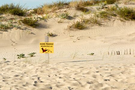 Beach Dunes and wooden picket fence, with sign warning "Do Not Walk On Dunes"in frenchの写真素材