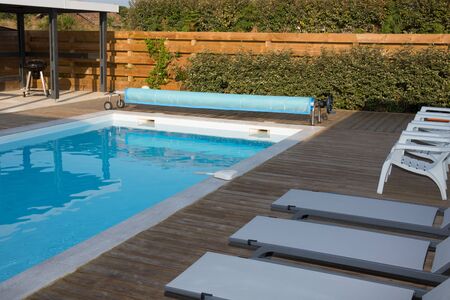 Architecture; beautiful garden with pool, four sunbeds view
