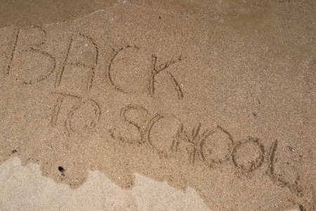 Back to school sign on the beach sandの写真素材