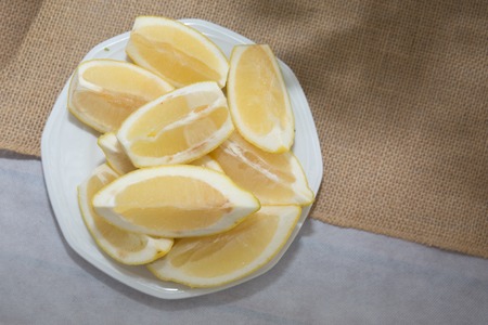 Plenty of sliced, lemon on a plate on a tableの写真素材