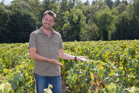 Happy and smiling winemaker man in a his vineyard