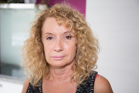 Sad Mature Woman Suffering From Agoraphobia Looking Out Of Windowの写真素材