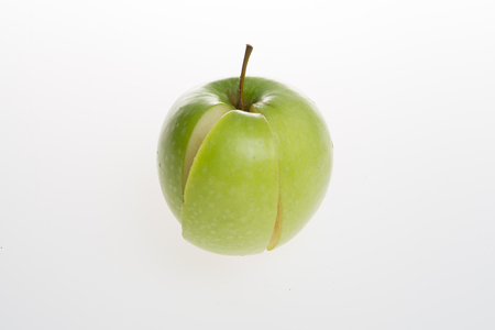 apple with slice, green and white backgroundの写真素材