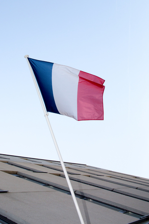 A French flag waving over a blue skyの写真素材
