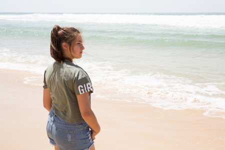 back view of teenager girl on sand beach summerの写真素材