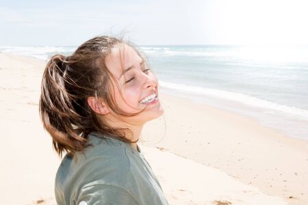 smiling happy cute teenager girl in ocean sea beachの写真素材