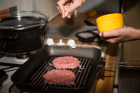 chef on the kitchen table making out the ingredients of the Burger. Beef Patty cookedの写真素材