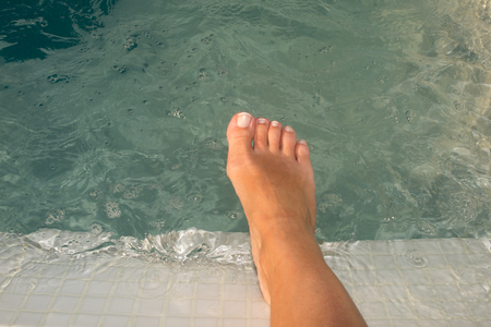 Pleasant woman holding her legs in the swimming poolの写真素材