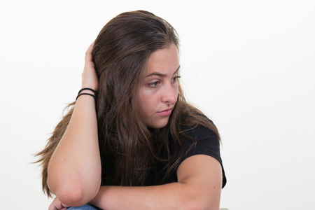 Sad teenage girl sitting near windowの写真素材