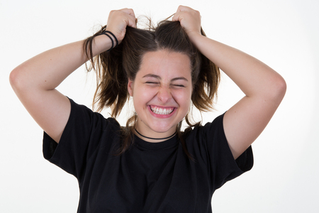 portrait teenager girl on a white background hands in hair for fun attitudeの写真素材