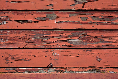 abstract image of fading red paint on an old wooden building exteriorの写真素材