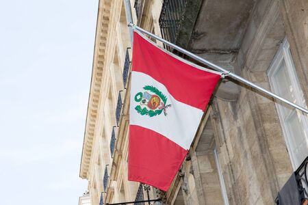 Peru flag on the mast waving against building in streetの写真素材
