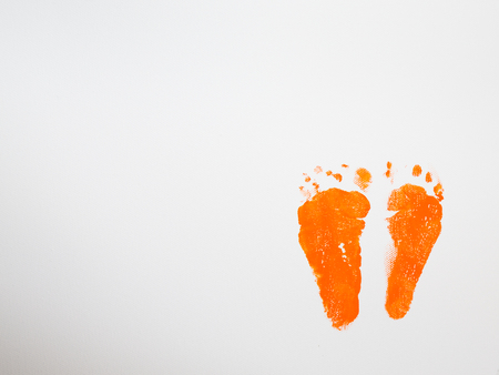 foot prints with orange paint in white canvasの写真素材