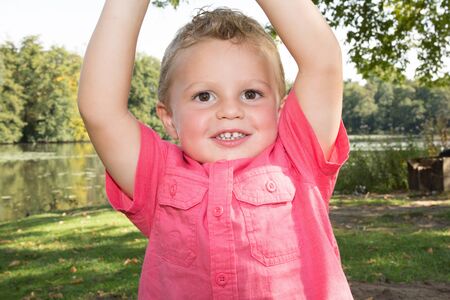 Portrait of a happy little boy in a summer park