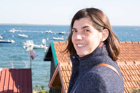 Beautiful smiling woman portrait close up in seaside in winterの写真素材