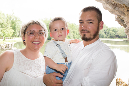 happy mother and father loving his little son in parkの写真素材