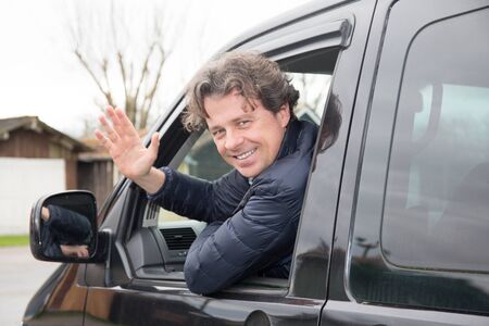 Mature man driving van Caucasian guy having fun while travelling in a  vanの写真素材