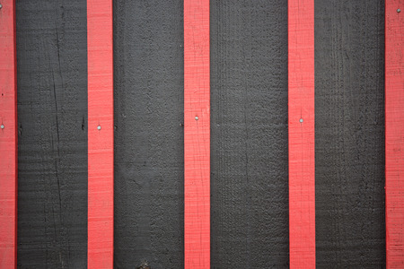 red painted strips of wood on a wooden black backgroundの写真素材