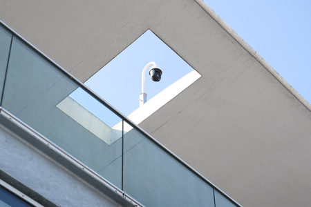a video camera surveillance over a modern rooftop buildingの写真素材