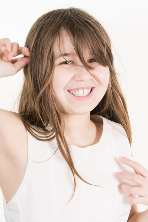 Portrait of a teen girl smiling on grey background in fun and happinessの写真素材