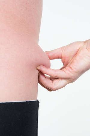 Fat man checking out his weight isolated on white backgroundの写真素材