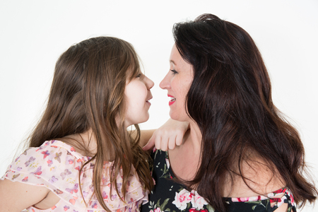 Close-up portrait of happy young little girl play with motherの写真素材