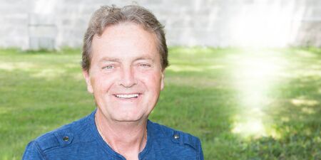 senior retired man is enjoying free time in his home gardenの写真素材