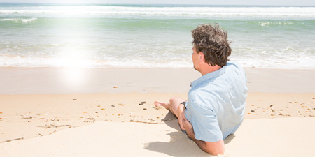 rear view alone single man lying on sea side sand look ocean beachの写真素材