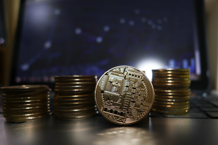 Stack and piles of Bitcoin and other different cryptocurrencies front computer
