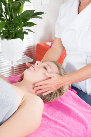 Beautiful Young blond Woman Getting a Face Treatment at Beauty Salonの写真素材