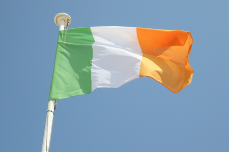 ireland flag on a mat in the wind and blue skyの写真素材
