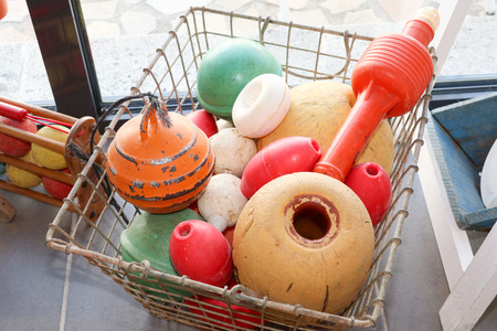 old fishing nets floats in a metal basket picked up on the beach