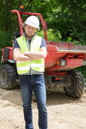 man manager in front of an excavator on construction site
