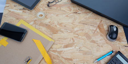 office wood desk background with phone laptop pen tabletの写真素材