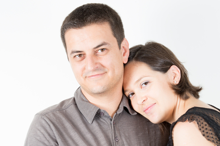 happy woman leaning on her man shoulder young casual couple smiling on white backgroundの写真素材