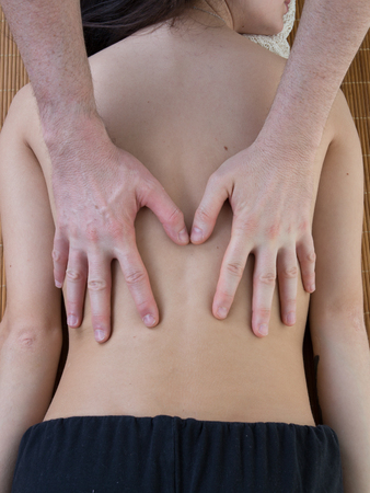Closeup of happy fit woman receiving back man massage at salon spaの写真素材