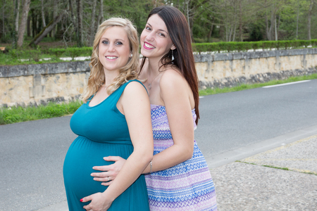 Happy girlfriends in love sharing time together blonde lesbian couple pregnancyの写真素材