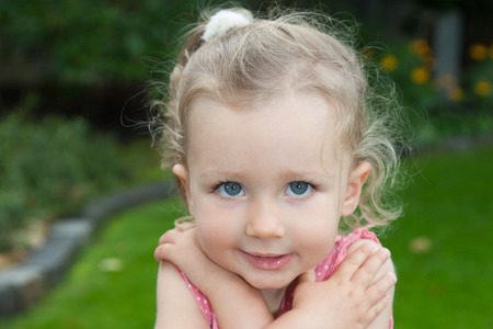 lovely blond child girl posing outdoor with blue eyesの写真素材