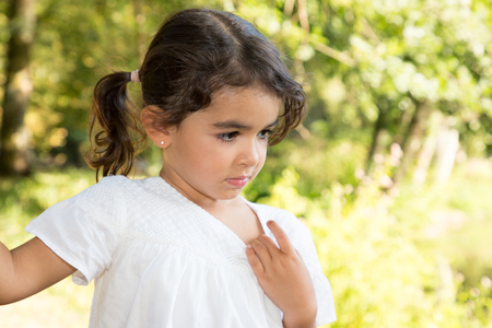 pensive child girl in sun day outdoor garden parkの写真素材