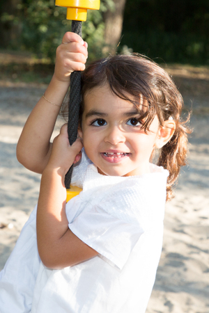 pretty tan child girl on the playgroundの写真素材