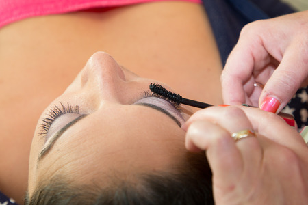 woman make up artist applying make up to a fashion model girl
